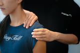 a therapist of Sportential doing shoulder injury assessment to a female patient.