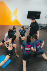 a team of female sports players doing warmup before S&C training in sportential training studio