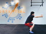 a middle aged man doing body weight squat in sportential training studio