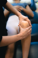 a therapist of Sportential doing knee injury assessment to a female patient