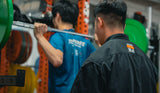 an instructor of sportential teaching a volleyball athlete squat during the S&C session in sportential training studio and clinic