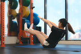 a female patient with back pain is doing rehabilitation exercise in sportential training studio and clinic