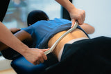 a therapist doing IASTM to a patient to release soft tissue and fascia