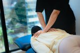 a therapist is doing the manipulation treatment to a patient with back pain